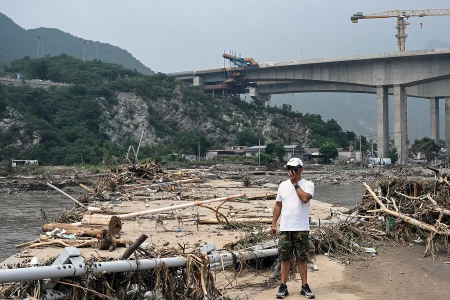 A man stands on a broken bridge at a flood-affected area following heavy rains in Beijing, China, on 3 August 2023. (Jade Gao/AFP)