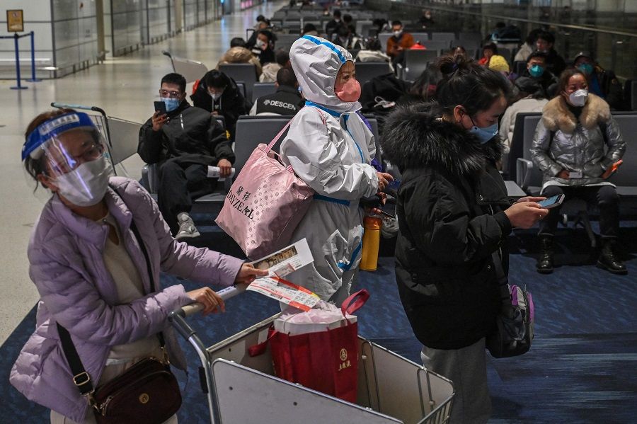 A passenger wearing protective clothing amid the Covid-19 pandemic waits to board a domestic flight at Shanghai Pudong International Airport in Shanghai, China, on 3 January 2023. (Hector Retamal/AFP)