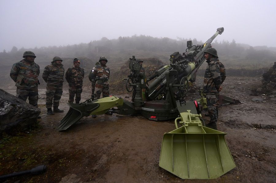 Indian Army soldiers stand next to a M777 Ultra Lightweight Howitzer positioned at Penga Teng Tso ahead of Tawang, near the Line of Actual Control (LAC), neighbouring China, in India's Arunachal Pradesh state on 20 October 2021. (Money Sharma/AFP)