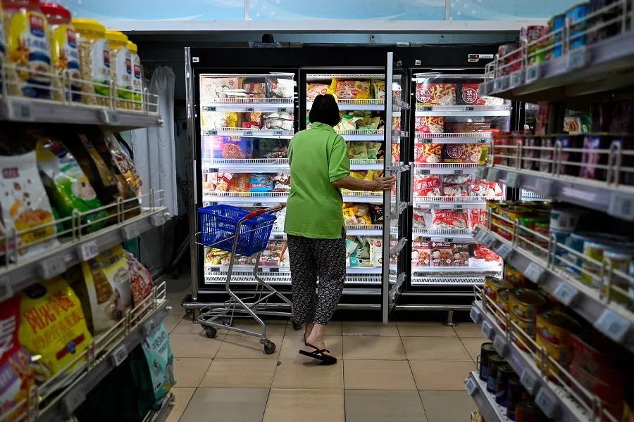 A woman shops for frozen items at a supermarket in Beijing, China, on 13 August 2023. (Pedro Pardo/AFP)