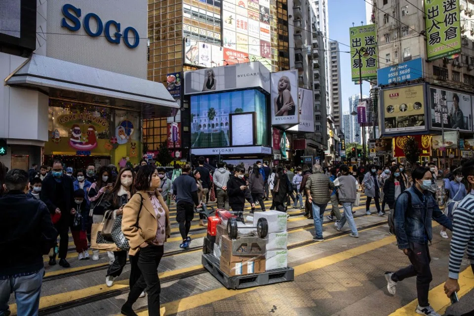 People walk through a shopping district in Hong Kong on 22 December 2022. (Isaac Lawrence/AFP)