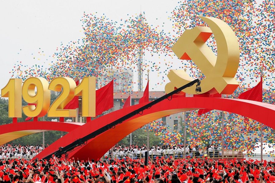 Participants wave national and party flags as balloons are released at the end of the event marking the 100th founding anniversary of the Communist Party of China, at Tiananmen Square in Beijing, China, 1 July 2021. (Carlos Garcia Rawlins/Reuters)