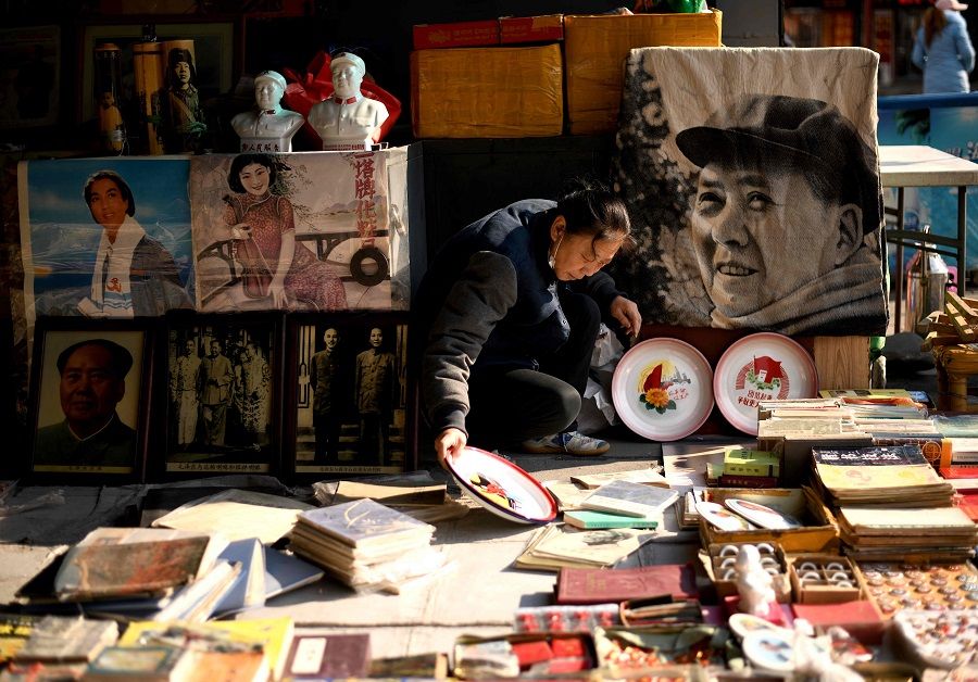 A vendor arranges books at her stall at the Panjiayuan antique market in Beijing, China, on 19 November 2020. (Noel Celis/AFP)