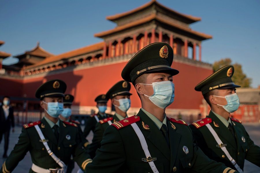 Paramilitary police officers wearing face masks march outside the Forbidden City in Beijing on 22 October 2020. (Nicolas Asfouri/AFP)