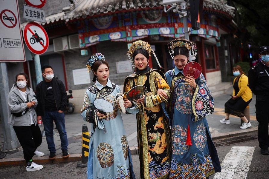 Women wearing traditional clothes walk near the Forbidden City in Beijing, China, 5 October 2021. (Thomas Peter/Reuters)