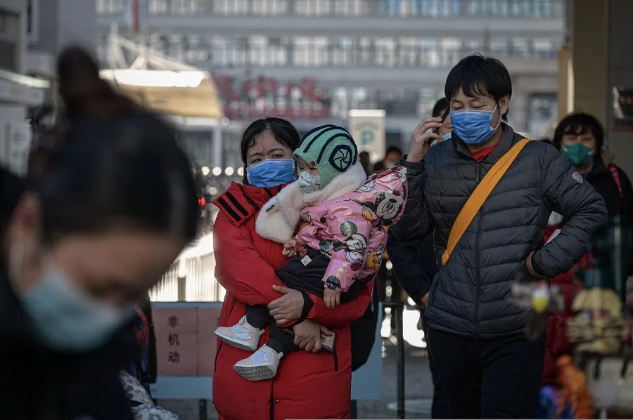 People wearing face masks walk out of a children’s hospital in Beijing on 10 January 2025.