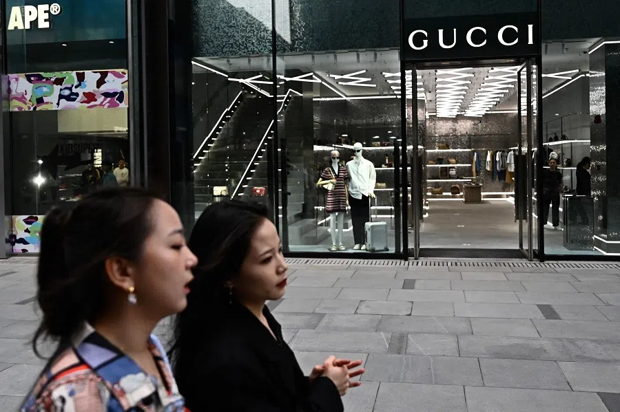 People walk past a Gucci store in Beijing on 20 April 2025. (Pedro Pardo/AFP)