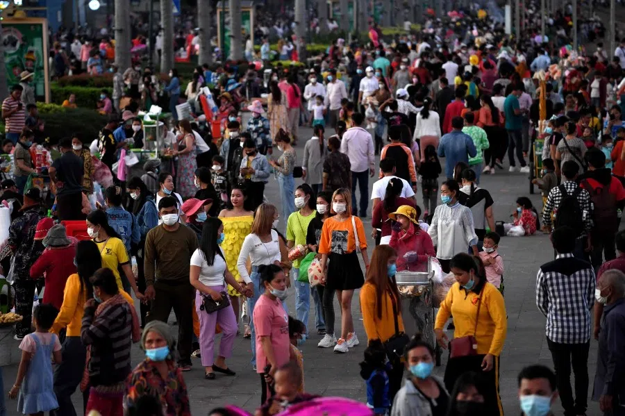 People walk along the riverside in front of the Royal Palace in Phnom Penh on 19 November 2021. (Tang Chhin Sothy/AFP)