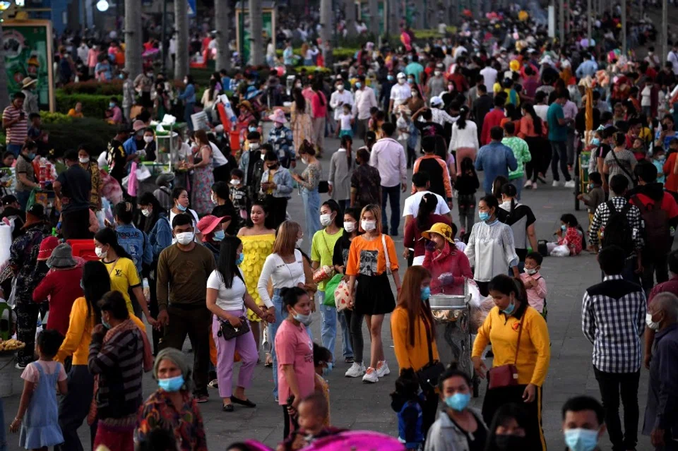 People walk along the riverside in front of the Royal Palace in Phnom Penh on 19 November 2021. (Tang Chhin Sothy/AFP)