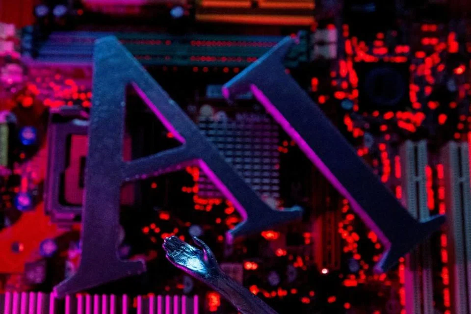 AI (Artificial Intelligence) letters and robot hand are placed on computer motherboard in this illustration created on 23 June 2023. (Dado Ruvic/Reuters)