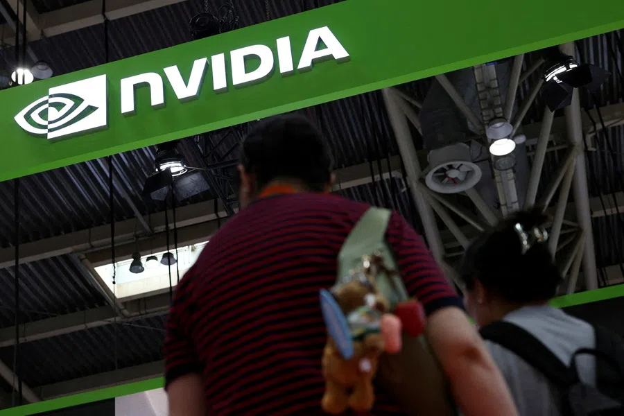 People stand near the Nvidia logo at its booth during the China International Supply Chain Expo in Beijing, China, 16 July 2025. (Florence Lo/Reuters)