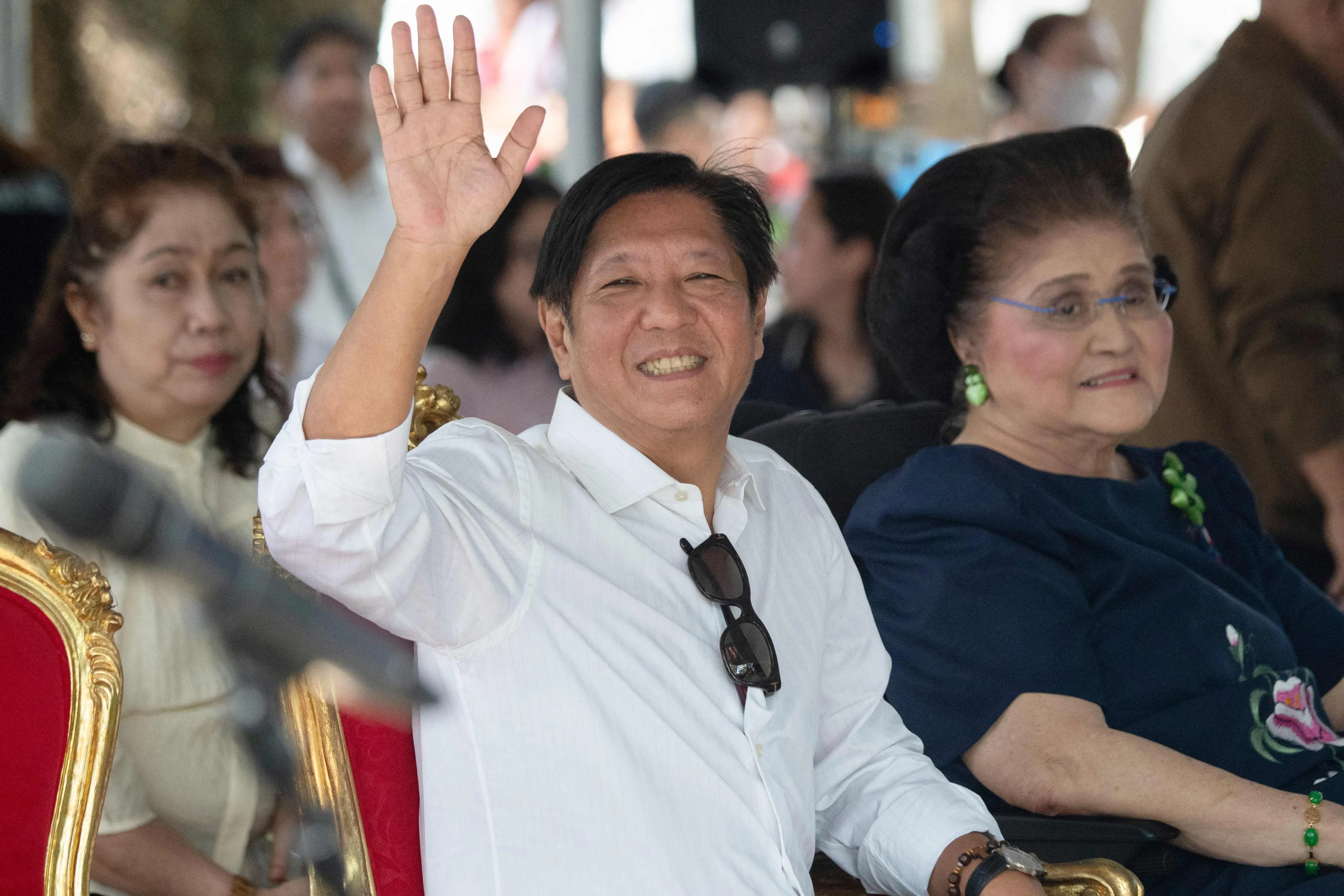 Philippine President Ferdinand Marcos waves as he sits with his mother, former first lady Imelda Marcos, as they visit the tomb of former president Ferdinand Marcos Sr after a mass to commemorate All Saints’ Day at the Heroes Cemetery in Manila on 1 November 2024. 