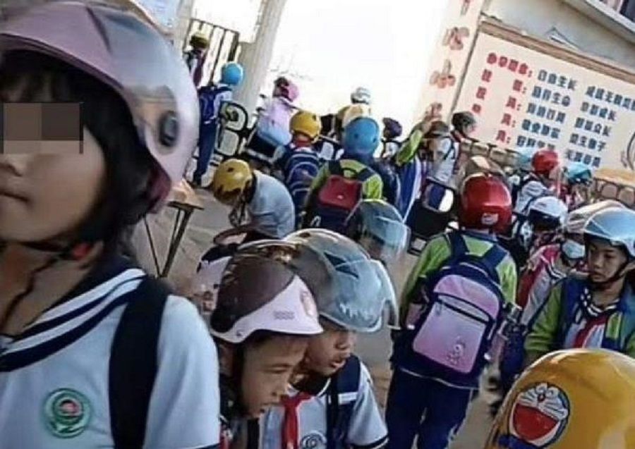 Controversy broke out over a primary school in China that required all students to wear helmets to and fro school. (Weibo)