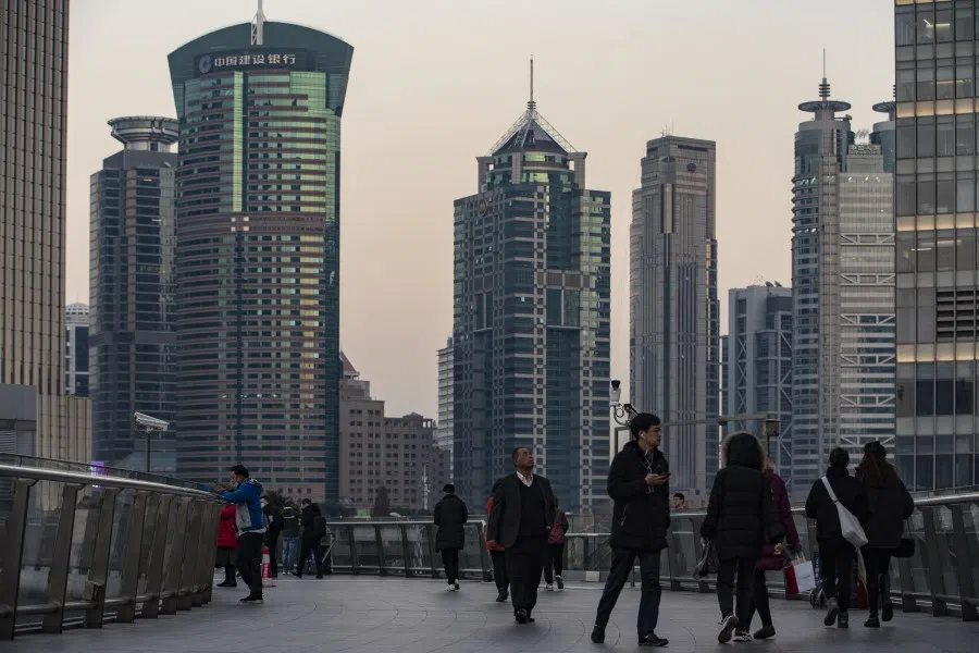 Pedestrians walk on an overpass in the Lujiazui financial district in Shanghai, China, 21 December 2020. (Qilai Shen/Bloomberg)