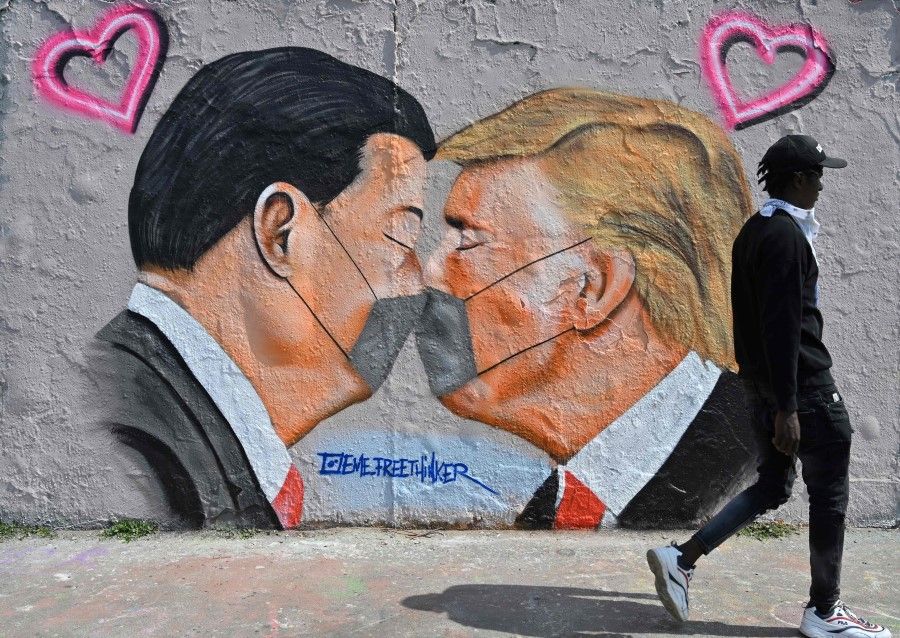 A mural featuring US President Donald Trump (R) and Chinese President Xi Jinping wearing face covers in Berlin on April 28, 2020. (John Macdougall/AFP)