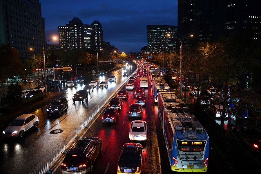Cars and buses clog a road during the evening rush hour at dusk in Beijing on 18 November 2020. (Greg Baker/AFP)