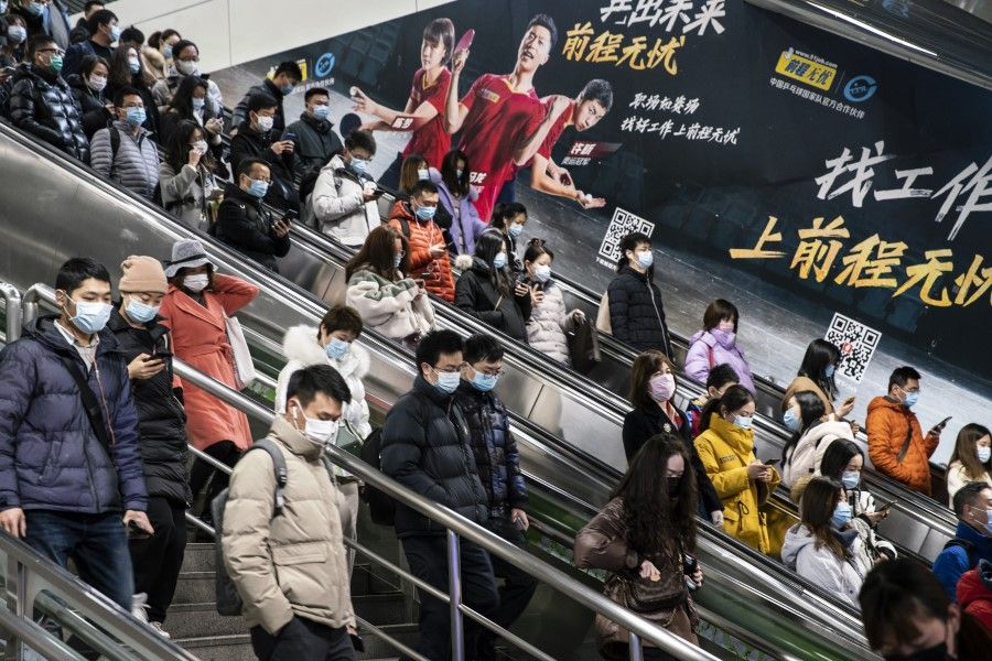 Passengers wearing protective masks ride escalators at a subway station in Shanghai, China, on 18 February 2021.(Qilai Shen/Bloomberg)