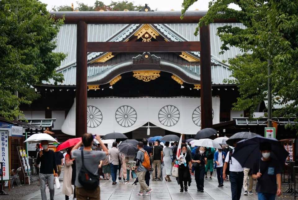 People carry umbrellas as they visit Yasukuni Shrine in Tokyo, Japan, 15 August 2021. (Issei Kato/Reuters)