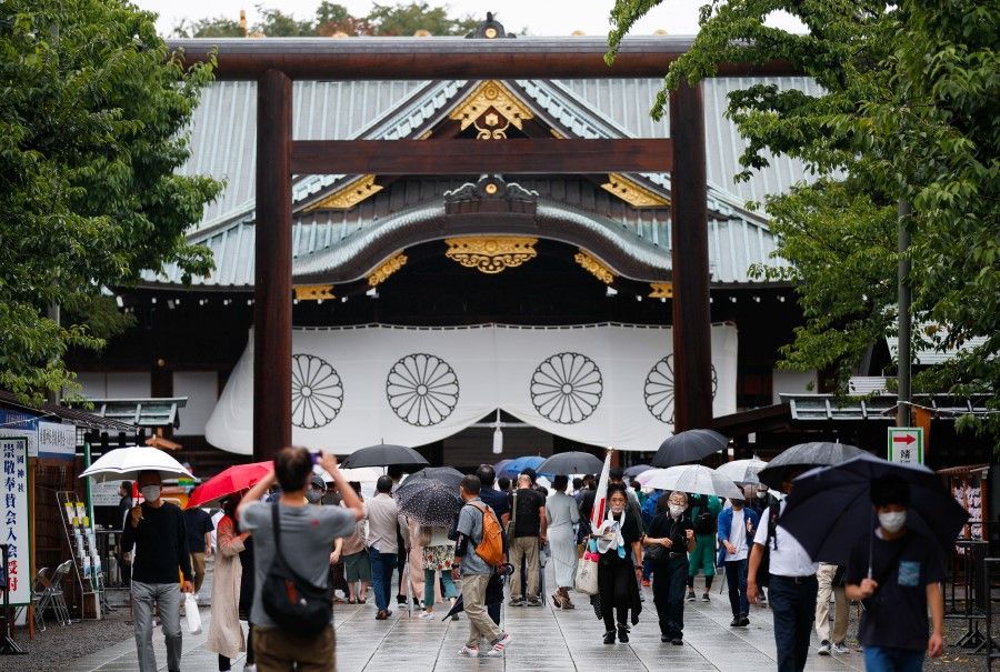 People carry umbrellas as they visit Yasukuni Shrine in Tokyo, Japan, 15 August 2021. (Issei Kato/Reuters)