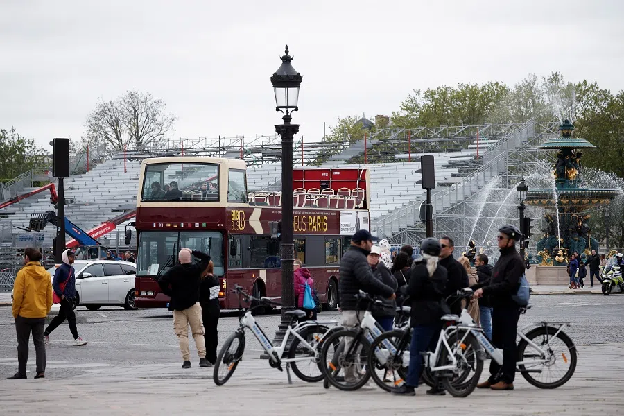 People walk as workers install bleachers at the Parc Urbain La Concorde, the venue under construction for the Paris 2024 Olympic and Paralympic Games in Paris, France on 19 April 2024. (Benoit Tessier/Reuters)
