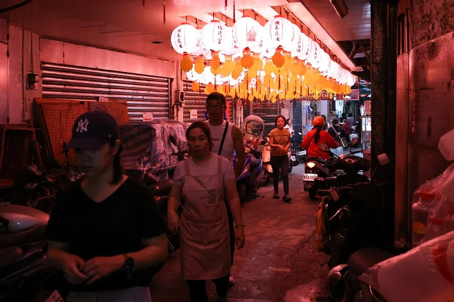 People walk in an alley lit up by lanterns in Keelung, Taiwan, on 23 May 2024. (Ann Wang/Reuters)