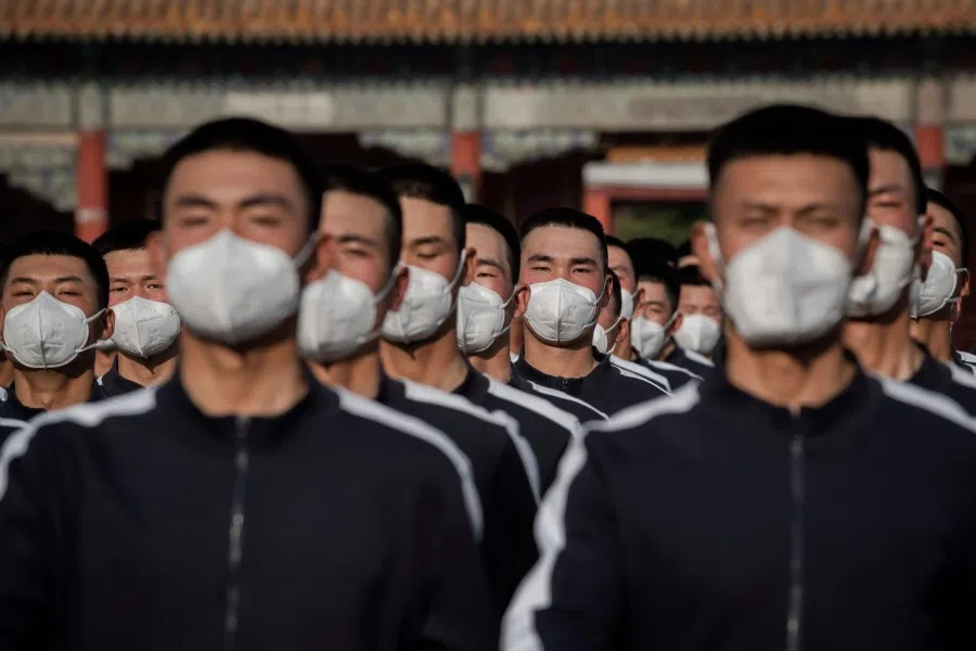 People's Liberation Army (PLA) soldiers in sports uniform march next to the entrance to the Forbidden City (back) after the opening session of the National People's Congress (NPC) in Beijing, 22 May 2020. (Nicolas Asfouri/AFP)