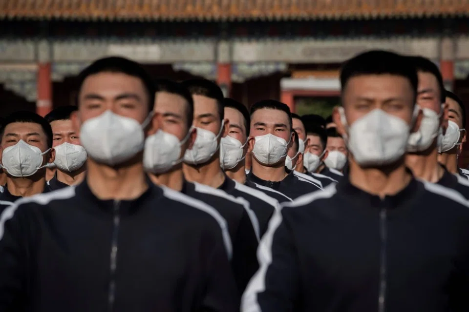 People's Liberation Army (PLA) soldiers in sports uniform march next to the entrance to the Forbidden City (back) after the opening session of the National People's Congress (NPC) in Beijing, 22 May 2020. (Nicolas Asfouri/AFP)