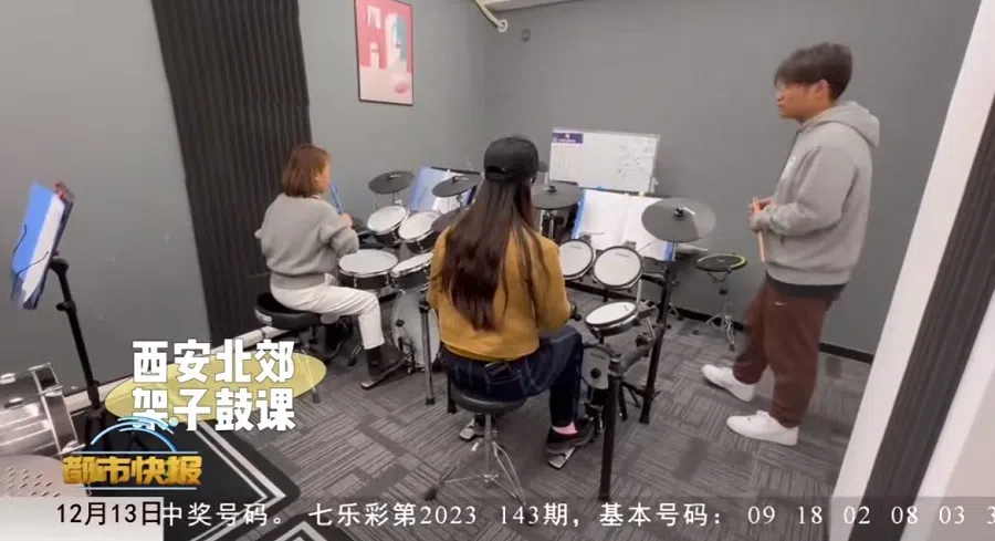 People attend drum lessons at a night school in China. (Screenshot from Weibo video)