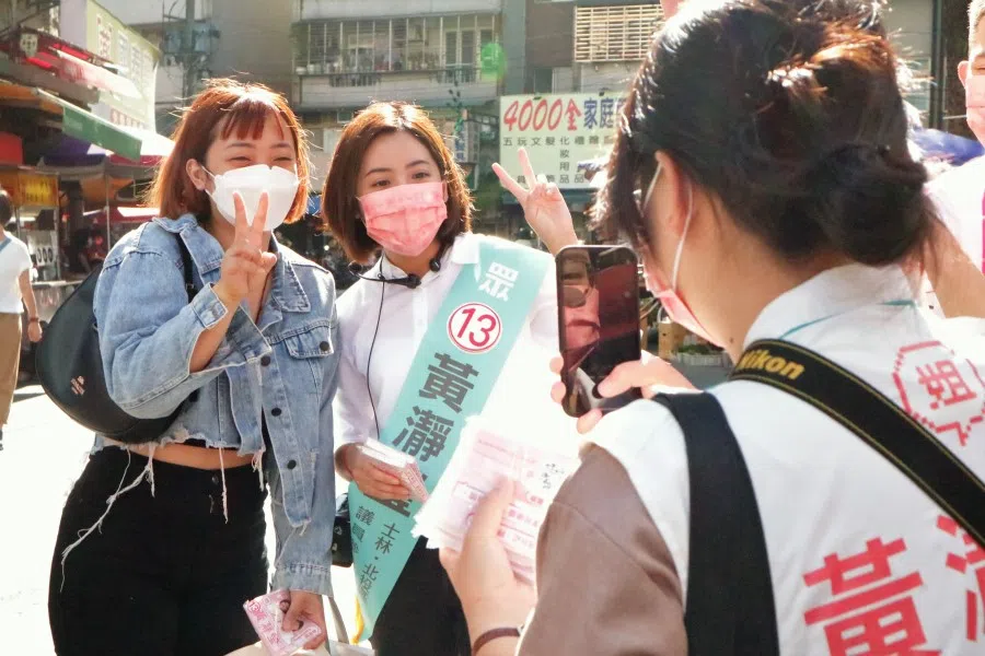 Huang Ching-yin of the Taiwan People's Party, running to represent Shilin and Beitou districts in Taipei city, has a photo taken with a voter, 17 November 2022. (SPH Media)