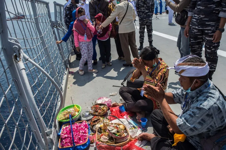 Family members attend a remembrance ceremony for the crew of the Indonesian navy submarine KRI Nanggala that sank on 21 April 2021 during a training exercise, on the deck of the hospital ship KRI Dr. Soeharso off the coast of Bali on 30 April 2021. (Juni Kriswanto/AFP)