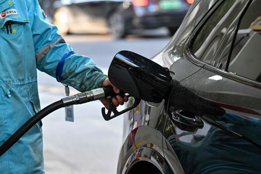 A worker fills the tank of a car at a gasoline station in Shanghai on 27 March 2026.