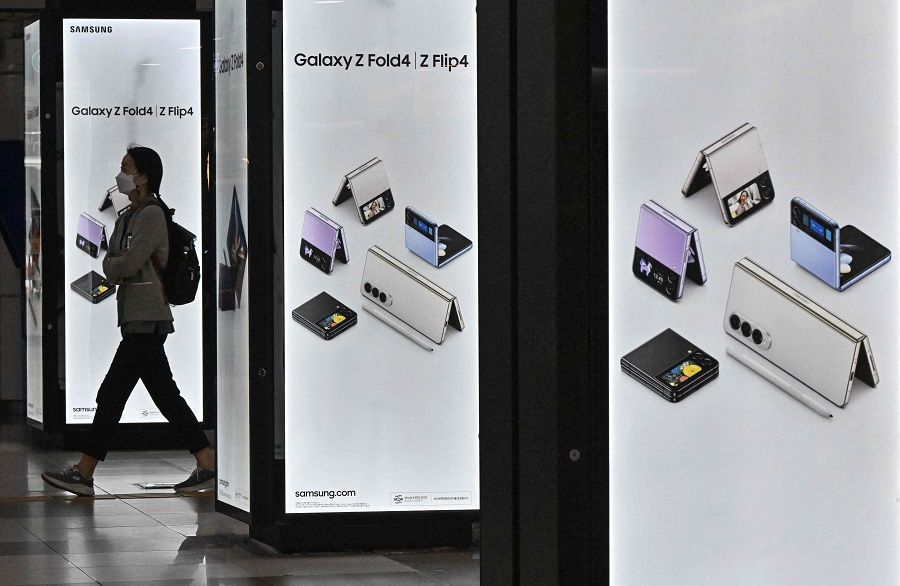 A woman walks past a Samsung advertisement at a subway station in Seoul, South Korea, on 27 October 2022. (Jung Yeon-je/AFP)