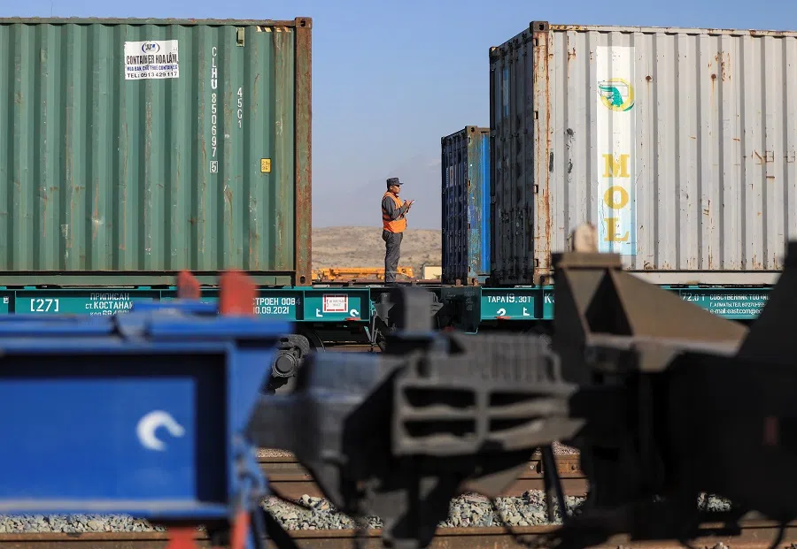 A railway worker checks shipping containers at the Altynkol railway station near the Khorgos border crossing point on the border with China in Kazakhstan, on 26 October 2021. (Pavel Mikheyev/Reuters)