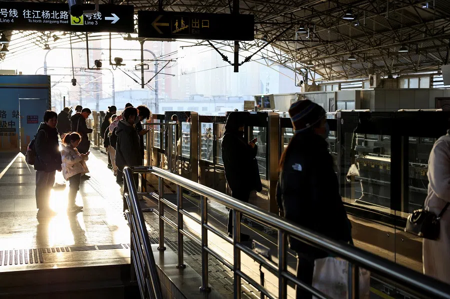 People stand at a metro station, in Shanghai, China, on 16 January 2025. (Go Nakamura/Reuters)