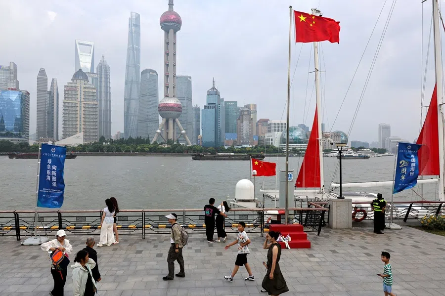 People walk on a promenade in Shanghai, China, on 10 July 2025.