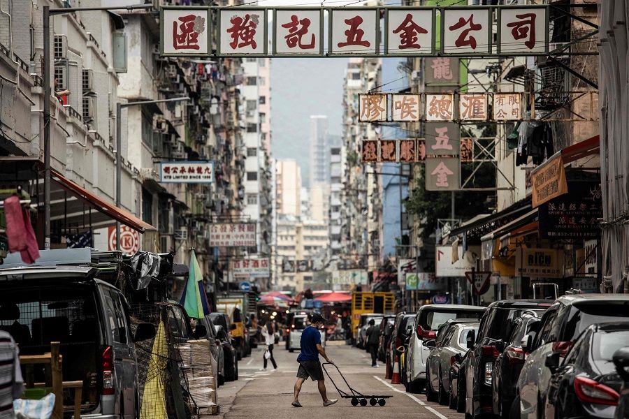 A man pushes a trolley across a street in the Kowloon district of Hong Kong, China, on 22 November 2022. (Isaac Lawrence/AFP)