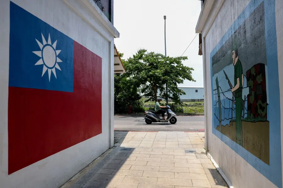 A motorist commutes past paintings on a wall of the Taiwan flag and a soldier in Taiwan’s Kinmen on 18 May 2024.