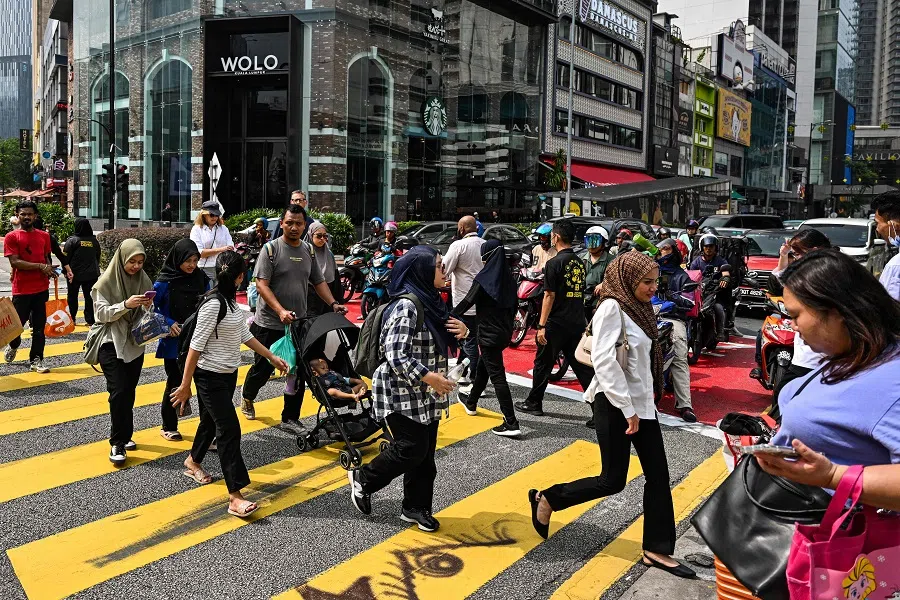 Pedestrians cross a road in Kuala Lumpur, Malaysia, on 24 April 2024.