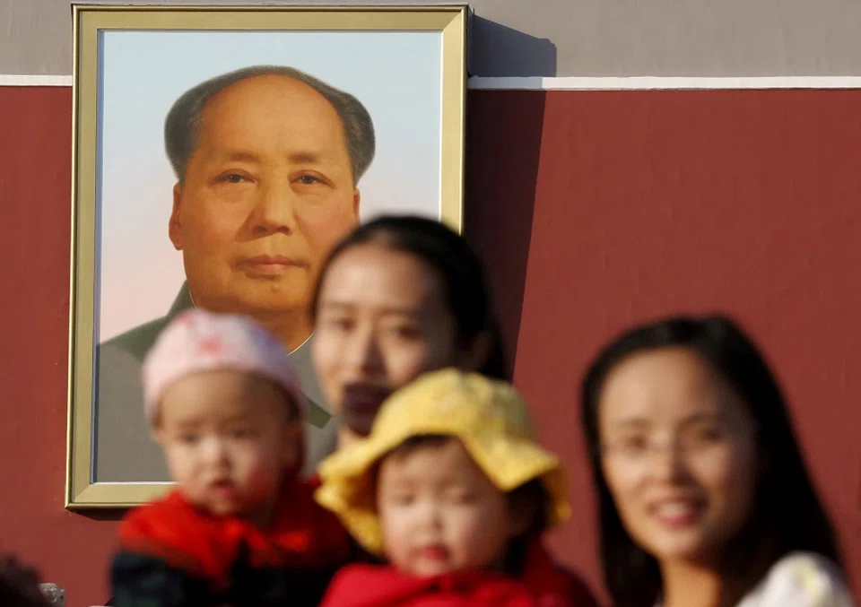 Two women and their babies pose for photographs in front of the giant portrait of late Chinese chairman Mao Zedong on the Tiananmen Gate in Beijing, China, 2 November 2015. (Kim Kyung-Hoon/File Photo/Reuters)