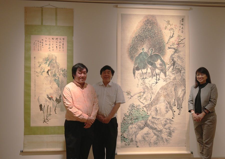 Yeo Eng Koon (centre) with his son and wife standing beside a Ren Bonian painting. (SPH Media)