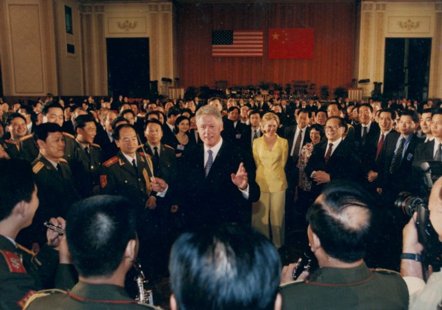 US President Bill Clinton conducting a Chinese band in playing God Bless America at the Great Hall of the People, 1998.