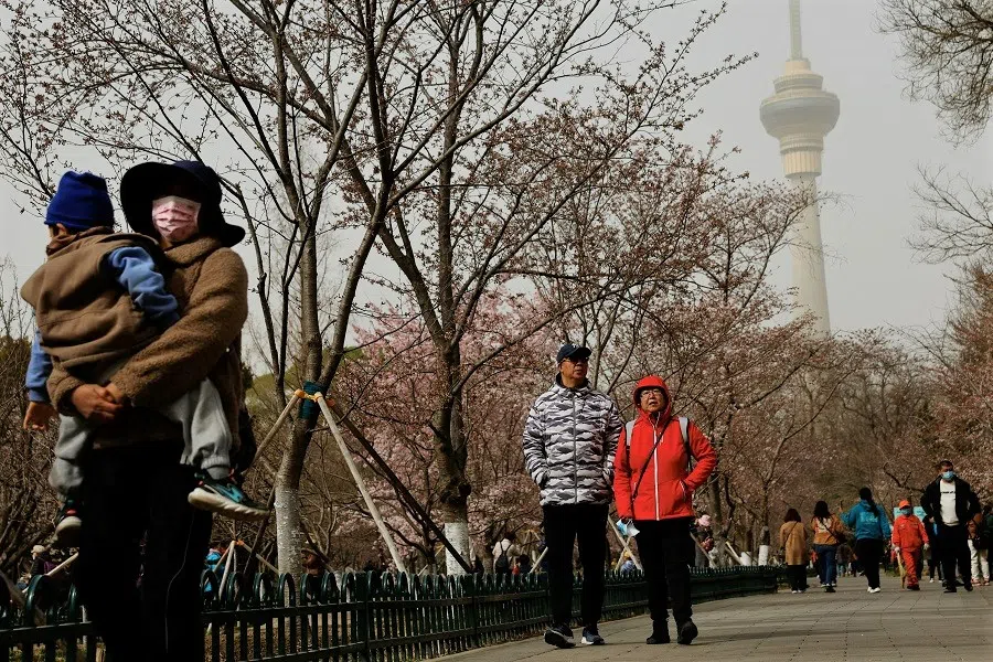 People walk amid a sandstorm at a park in Beijing, China, 22 March 2023. (Tingshu Wang/Reuters)
