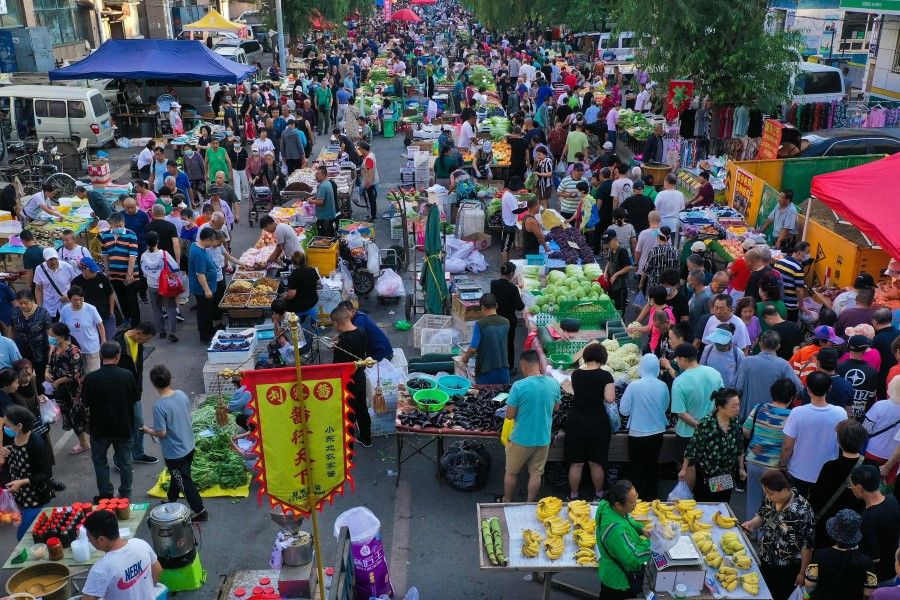 People visit a market in Shenyang, in China's northeastern Liaoning province, on 9 August 2023. (AFP)