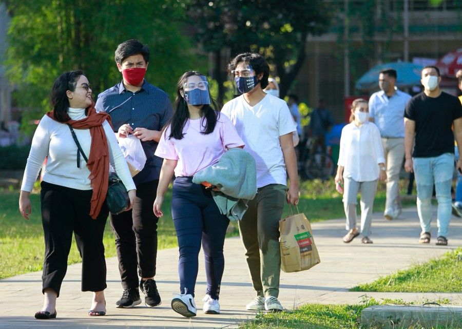 People wearing protective face masks and face shields walk at the park amid the coronavirus disease (COVID-19) outbreak, in Jakarta, Indonesia, 22 August 2020. (Ajeng Dinar Ulfiana/REUTERS)