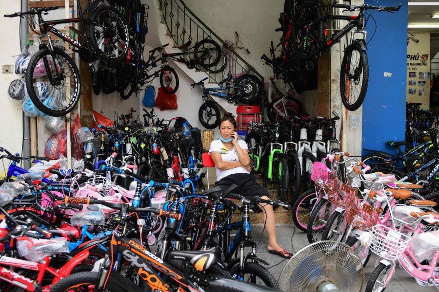 A woman speaks on her mobile phone at a bike shop in Hanoi on 29 June 2021. (Nhac Nguyen/AFP)
