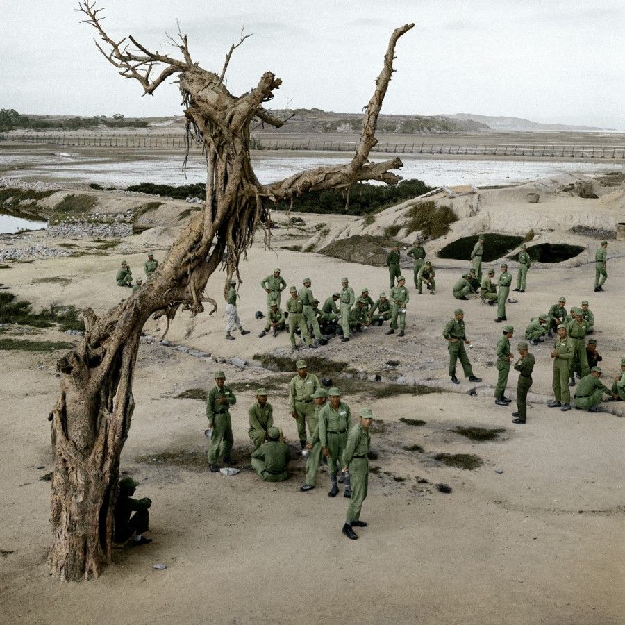 Kinmen facing Xiamen's coast, 1960. Soldiers resting after an exercise, overlooking a minefield and a beach full of anti-landing spikes against the CCP army. The withered tree adds to the desolation.