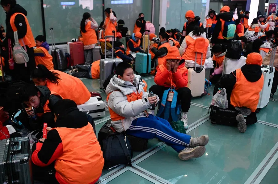 A group of students waits to check in at a railway station in Beijing on 14 January 2025. (Wang Zhao/AFP)