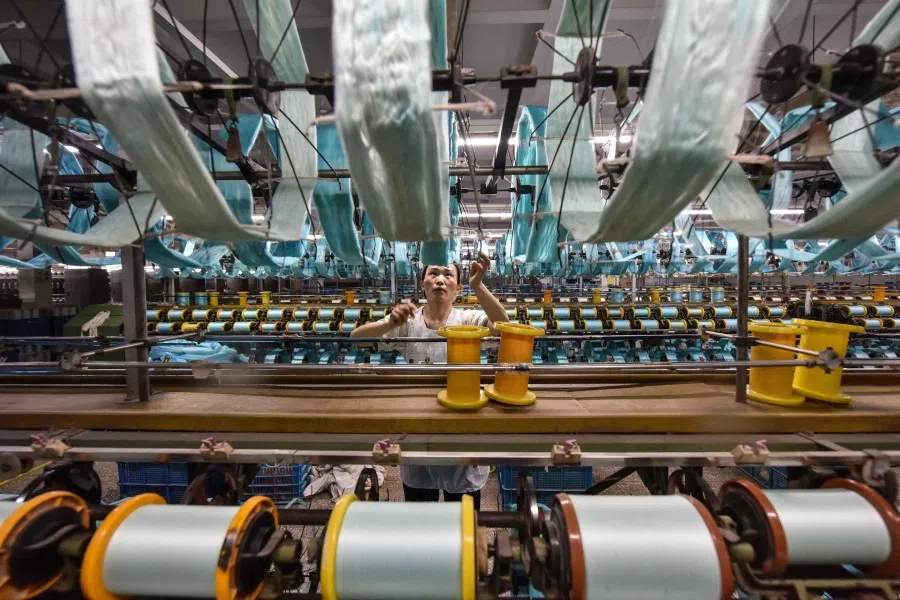 A worker produces silk products at a textile factory in Fuyang, in eastern China’s Anhui province on 16 April 2024. (AFP)
