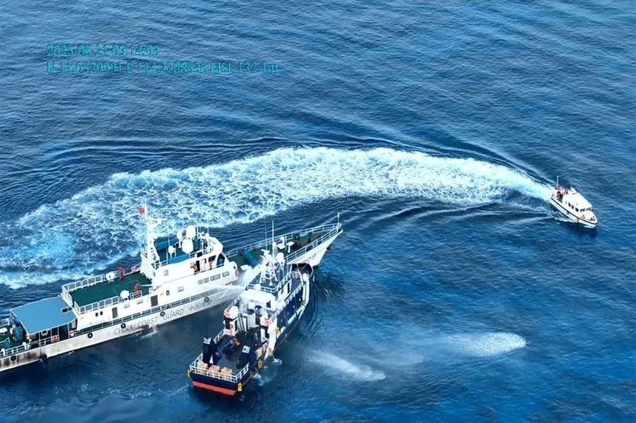 This screengrab photo released by the Bureau of Fisheries and Aquatic Resources (BFAR) and Philippine Coast Guard (PCG) taken on 21 May 2025 and released on 22 May 2025 shows a China Coast Guard ship (left) deploying a water cannon at a Bureau of Fisheries and Aquatic Resources (BFAR) ship (centre) near Sandy Cay reef in the disputed South China Sea. (Handout/Bureau of Fisheries and Aquatic Resources (BFAR) and Philippine Coast Guard (PCG)/AFP)