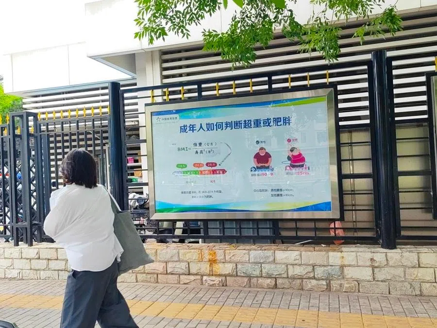 A person walks past a display educating the public about BMI.